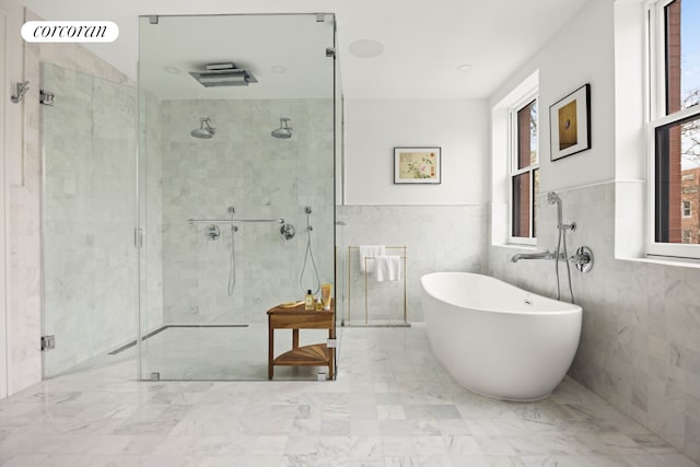 full bathroom with a shower stall, marble finish floor, and a freestanding bath