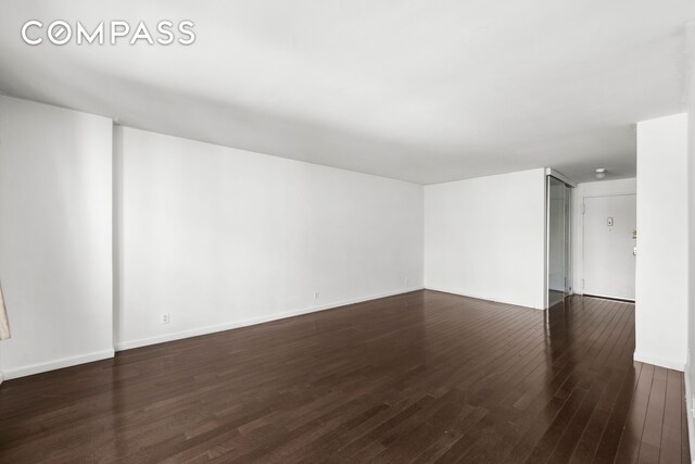 spare room with wood finished floors and baseboards