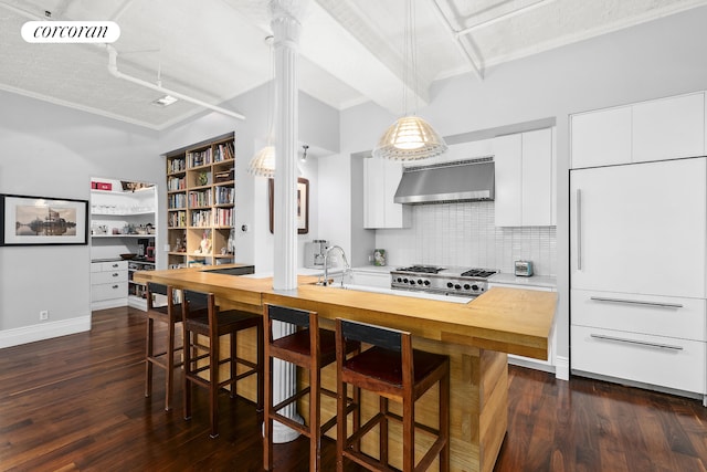 79 Worth St Unit 4R, New York City, NY 10013 - kitchen with exhaust hood, decorative backsplash, dark wood-style floors, white cabinets, and crown molding