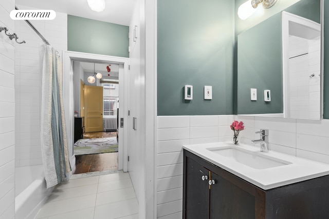 79 Worth St Unit 4R, New York City, NY 10013 - full bath featuring radiator heating unit, vanity, tile patterned flooring, and shower / bath combo with shower curtain