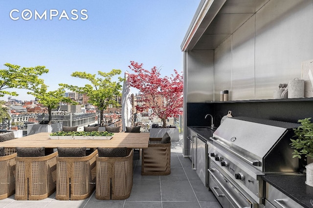 view of patio / terrace with an outdoor kitchen, a grill, and sink