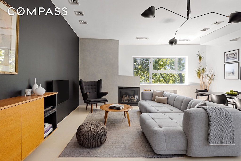 living room with a glass covered fireplace and visible vents