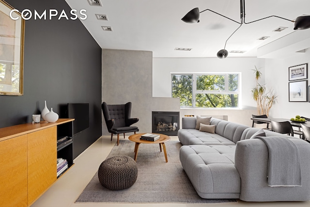 living room with a glass covered fireplace and visible vents