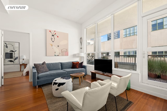 living room featuring wood finished floors, visible vents, and baseboards