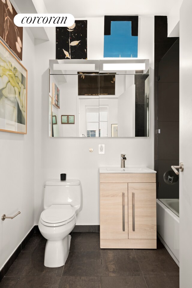full bathroom featuring baseboards, toilet, and vanity