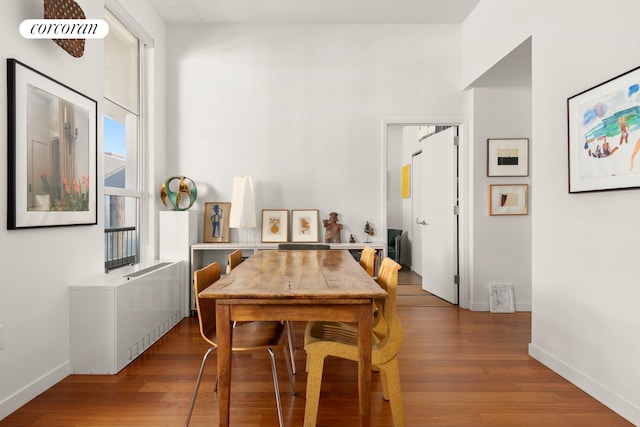 kitchen with stainless steel microwave, dark wood-style flooring, decorative backsplash, a peninsula, and white cabinetry