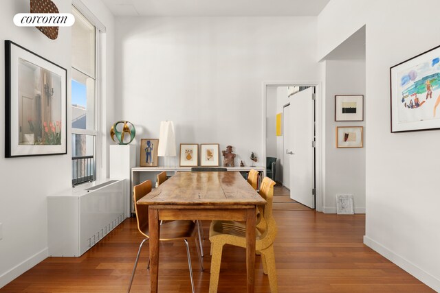 dining space with baseboards and wood finished floors