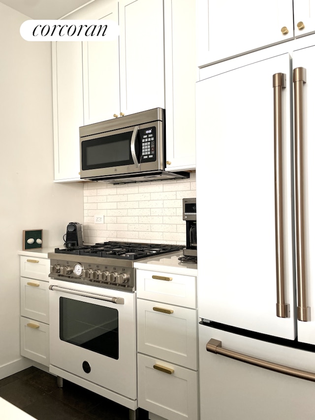 kitchen with white cabinets, high end appliances, decorative backsplash, and light countertops