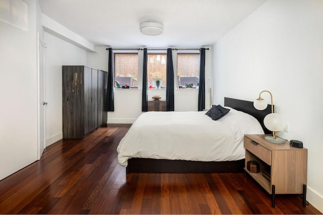 bedroom with dark hardwood / wood-style flooring