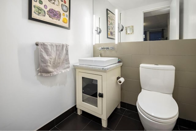 bathroom with vanity, tile walls, tile patterned floors, and toilet