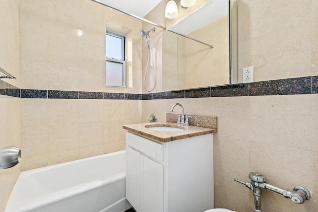 bathroom featuring vanity, tile walls, and tiled shower / bath