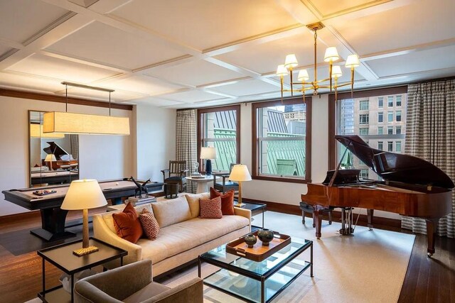 living room featuring coffered ceiling, hardwood / wood-style floors, and an inviting chandelier