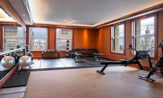 exercise room with a tray ceiling and recessed lighting