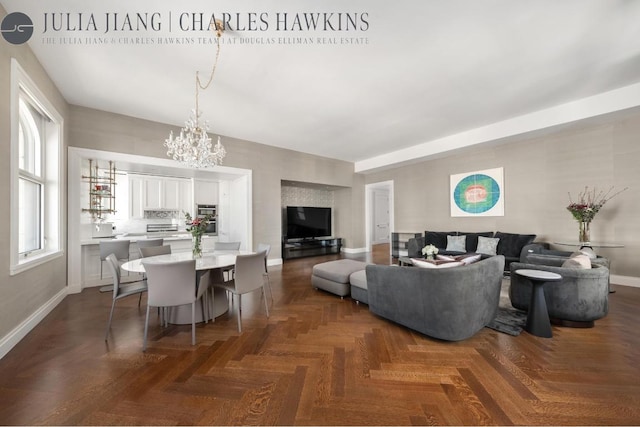 living room featuring an inviting chandelier and dark parquet floors