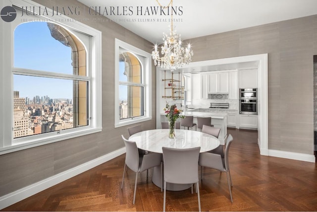 dining area with dark parquet flooring and a chandelier