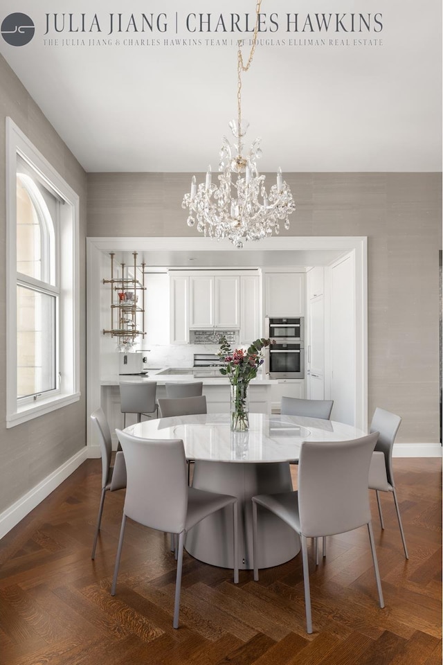 dining room featuring baseboards and an inviting chandelier
