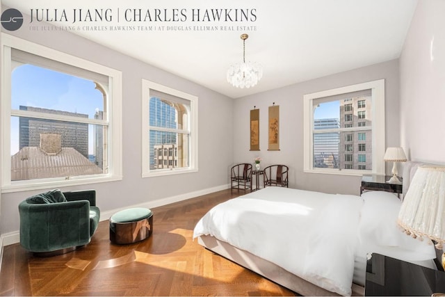 bedroom featuring parquet flooring and a chandelier