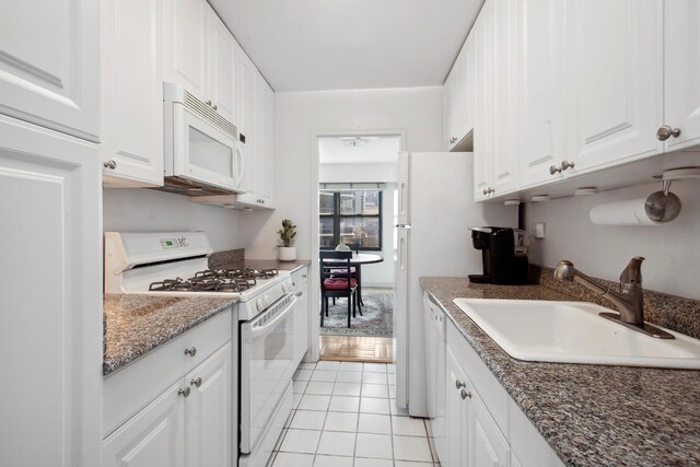 kitchen featuring white cabinetry, sink, light tile patterned floors, and white appliances