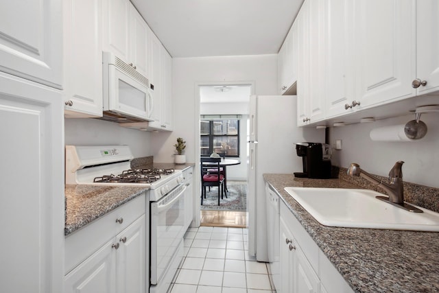 166 E 61st St Unit 9G, New York City, NY 10021 - kitchen featuring white appliances, a sink, white cabinets, light tile patterned flooring, and dark stone counters