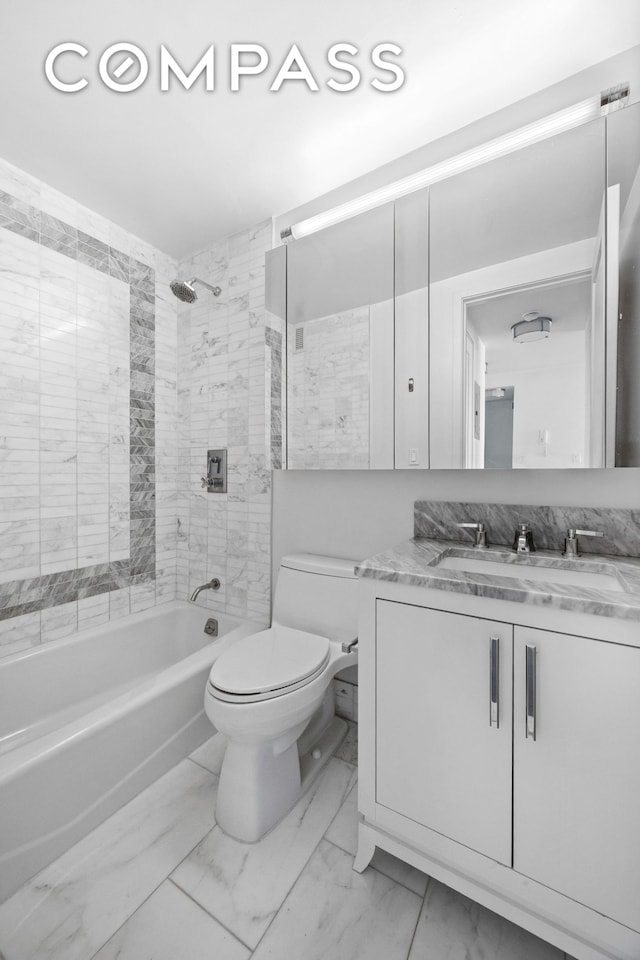 bathroom featuring marble look tile flooring, toilet, vanity, and shower / washtub combination