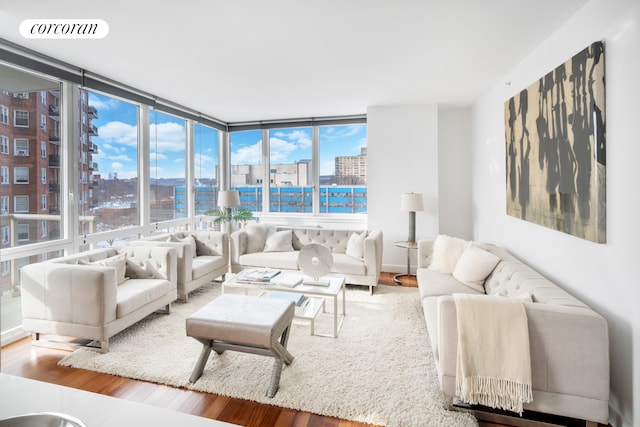 living area with visible vents, wood finished floors, a view of city, and plenty of natural light