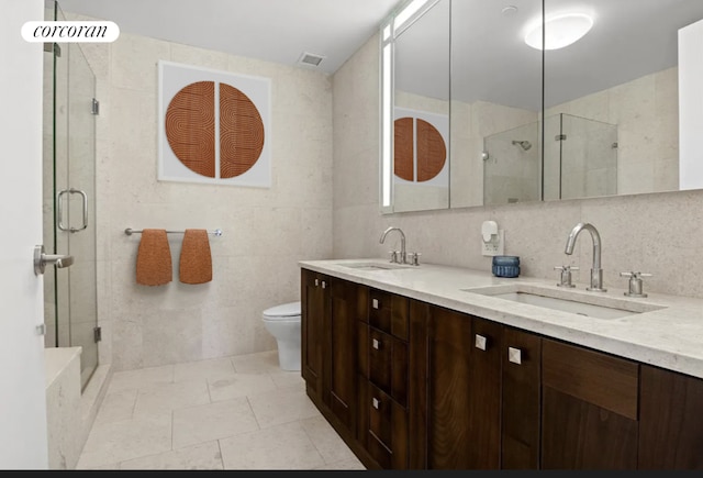 bathroom with toilet, a shower with shower door, tasteful backsplash, tile walls, and vanity