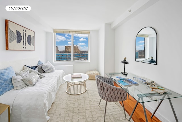 bedroom featuring a view of city, visible vents, baseboards, and wood finished floors