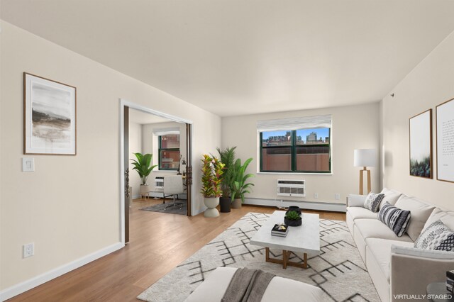 living room featuring a baseboard heating unit, a healthy amount of sunlight, a wall mounted AC, and light hardwood / wood-style floors