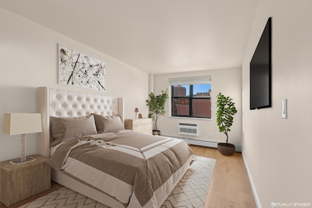 2235 Frederick Douglass Blvd Unit 7K, New York City, NY 10027 - bedroom featuring light wood-type flooring, a wall mounted air conditioner, and baseboards