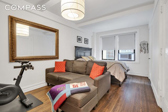 bedroom featuring beamed ceiling, baseboards, and dark wood finished floors