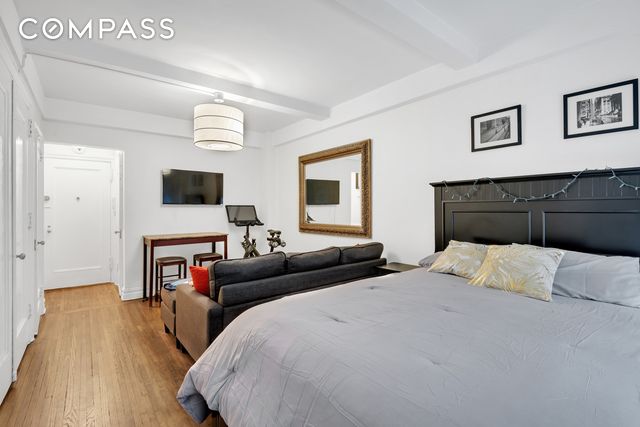 bedroom with beam ceiling and light hardwood / wood-style flooring