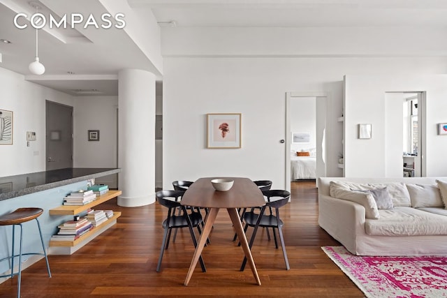 dining space with dark hardwood / wood-style flooring and decorative columns