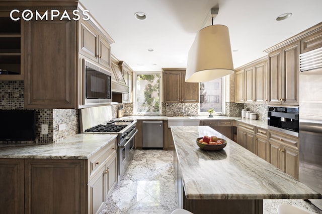 kitchen with backsplash, marble finish floor, built in appliances, and a center island