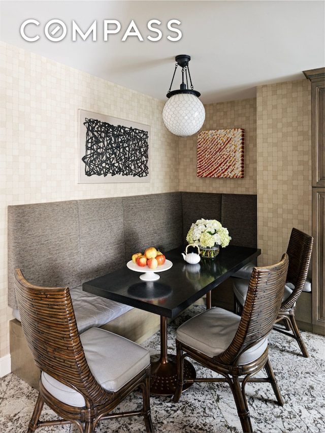 dining space featuring tile walls