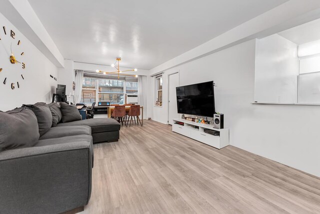 living area with light wood-style floors and a chandelier