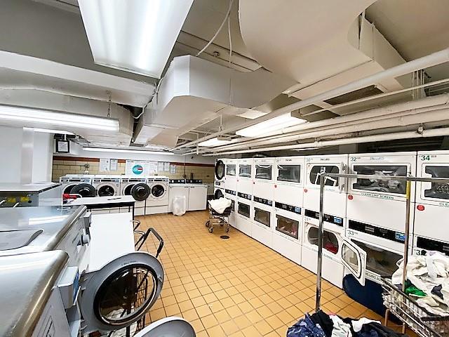 415 E 52nd St Unit 1-Cb, New York City, NY 10022 - kitchen featuring stacked washer and clothes dryer, washer and clothes dryer, tile patterned floors, and backsplash