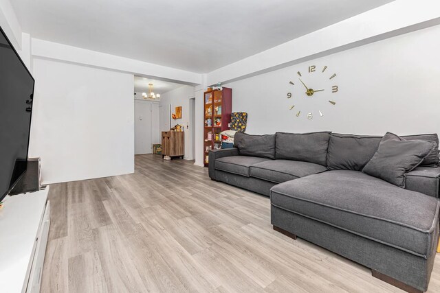 living room featuring a chandelier and light wood-type flooring