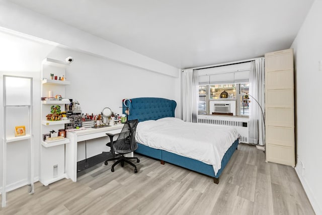 bedroom with radiator, light wood-style floors, and cooling unit