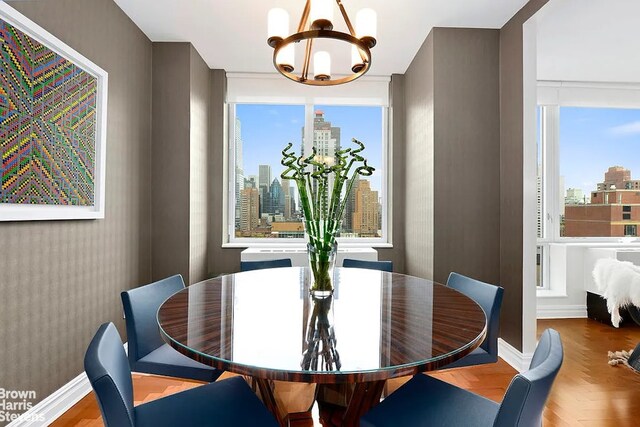 dining area featuring an inviting chandelier and parquet flooring