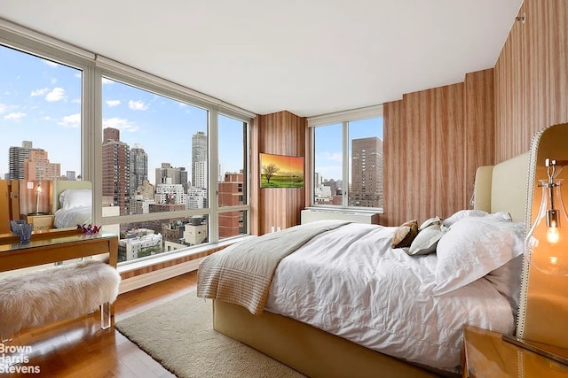 bedroom with a city view and wood finished floors