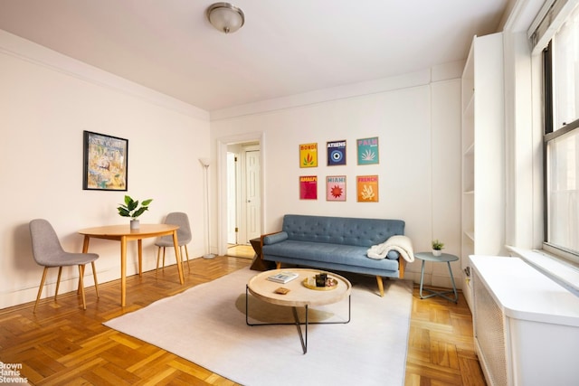 living room featuring ornamental molding and light parquet floors