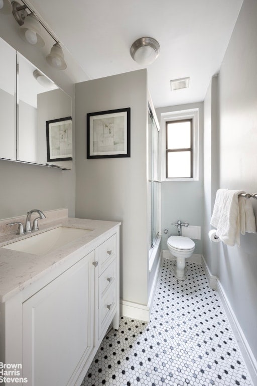 bathroom with vanity, toilet, and a shower with shower door