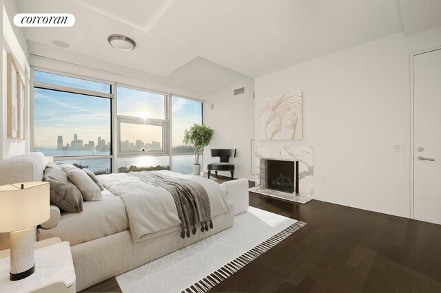 living room featuring hardwood / wood-style flooring, floor to ceiling windows, and a water view