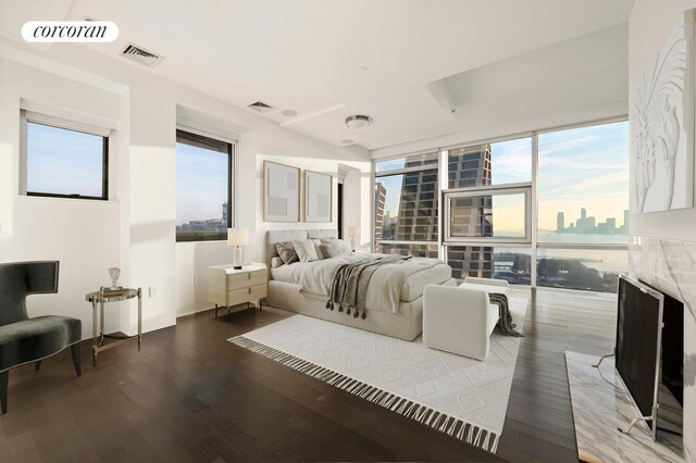 living room featuring wood-type flooring, expansive windows, and a water view