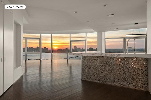 interior space with a view of city, visible vents, and dark wood finished floors