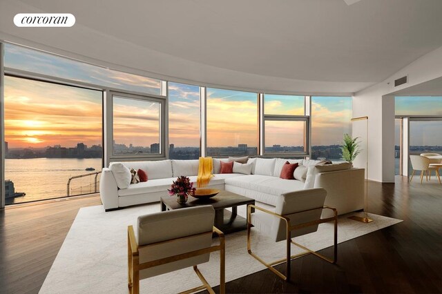 dining room with floor to ceiling windows, dark hardwood / wood-style floors, and a water view