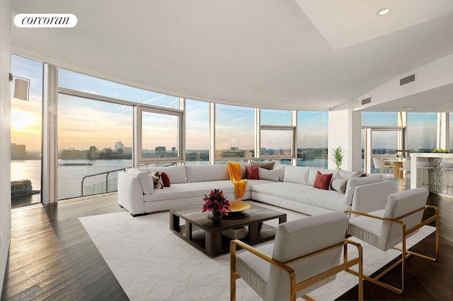 living room featuring a water view, a wall of windows, and wood-type flooring