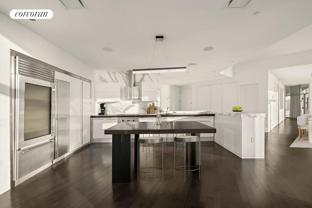 100 11th Ave Phb, Phb, New York City, NY 10011 - kitchen featuring visible vents, a center island, decorative backsplash, white cabinetry, and dark wood-style flooring