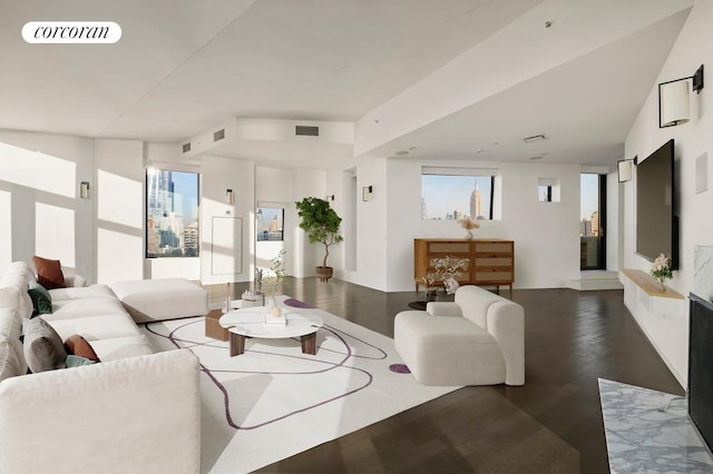 living area featuring visible vents and wood finished floors