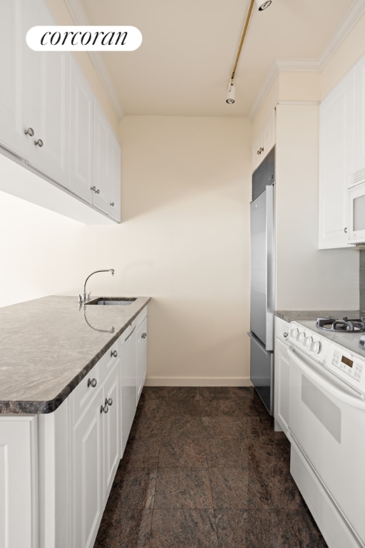 kitchen featuring white appliances, ornamental molding, sink, and white cabinets